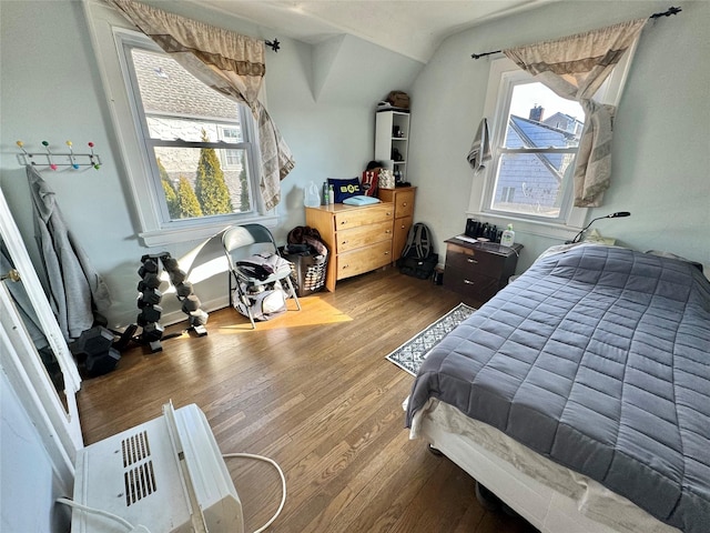 bedroom featuring multiple windows, light hardwood / wood-style flooring, and lofted ceiling