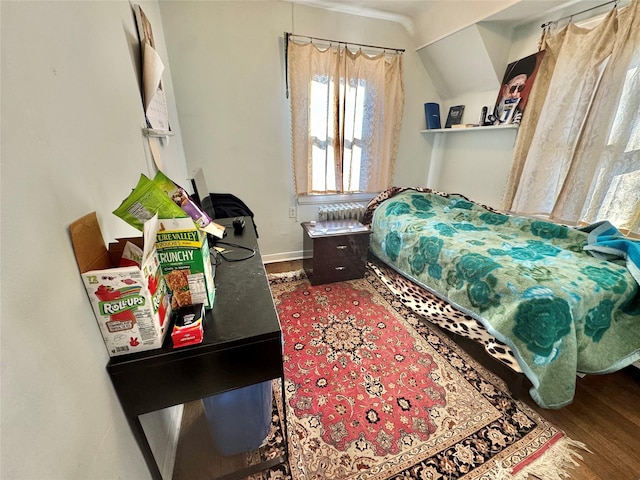 bedroom with vaulted ceiling and hardwood / wood-style flooring