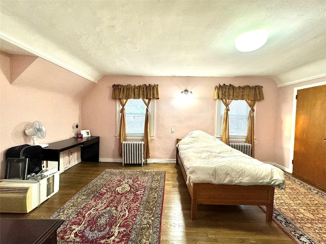 bedroom featuring lofted ceiling, dark wood-type flooring, radiator heating unit, and multiple windows