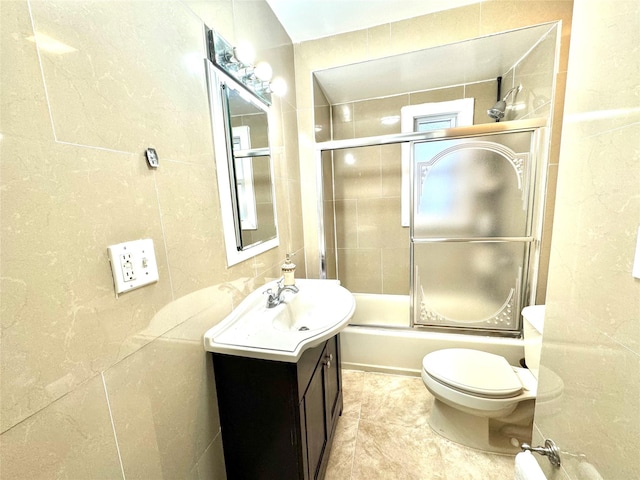 full bathroom featuring combined bath / shower with glass door, vanity, and toilet