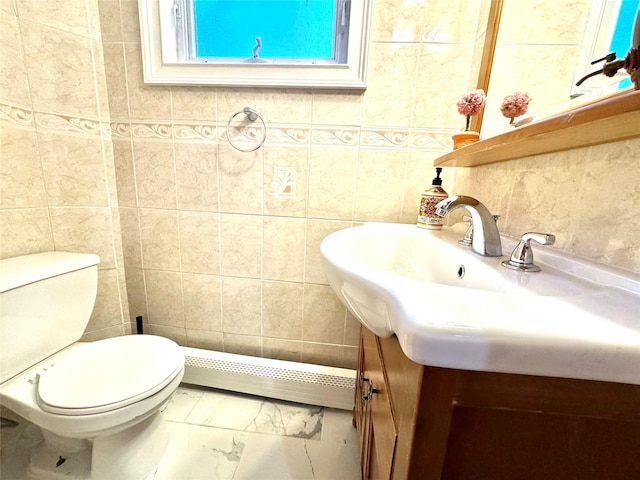 bathroom featuring toilet, tile walls, a baseboard heating unit, and vanity