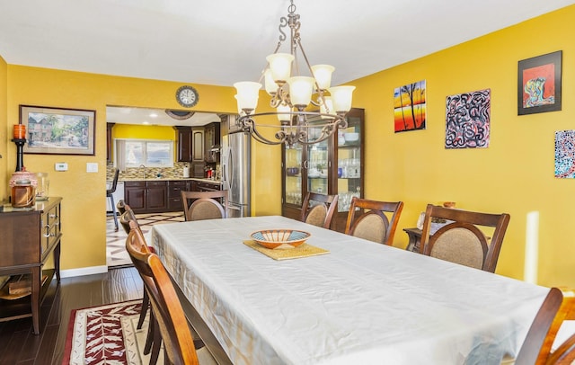 dining room featuring a chandelier, dark wood-type flooring, and sink