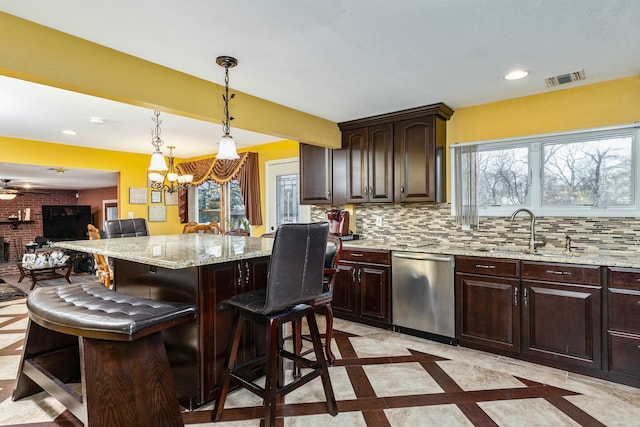 kitchen with backsplash, stainless steel dishwasher, a breakfast bar, sink, and a kitchen island