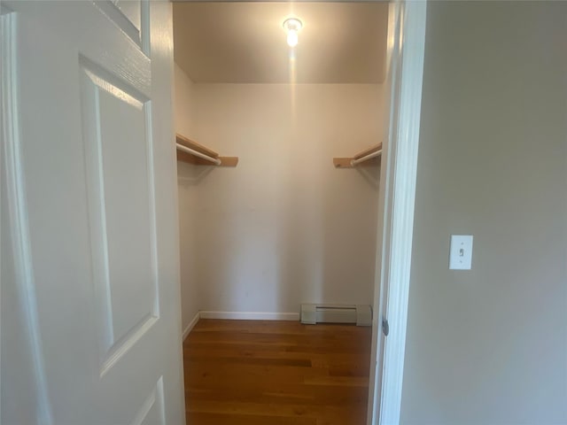 walk in closet featuring hardwood / wood-style flooring and a baseboard heating unit