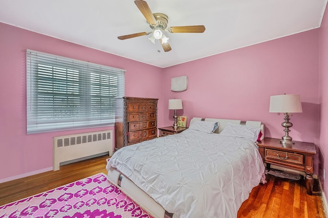 bedroom with radiator, ceiling fan, and wood-type flooring