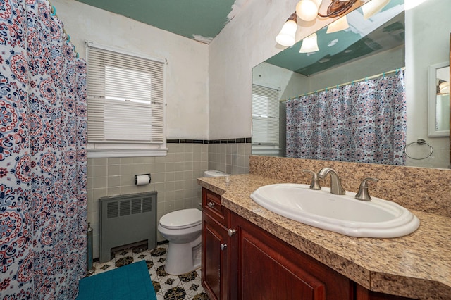 bathroom featuring vanity, radiator, toilet, tile walls, and curtained shower