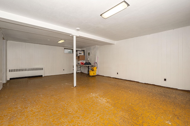 basement with wooden walls and radiator