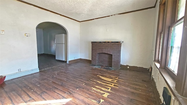 unfurnished living room with a fireplace, dark hardwood / wood-style flooring, ornamental molding, and a textured ceiling