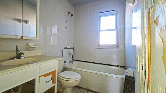 full bathroom featuring vanity, tile walls, tile patterned flooring, toilet, and tiled shower / bath