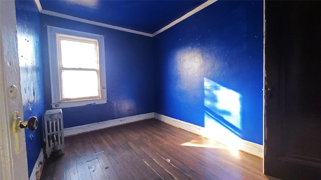 unfurnished room featuring hardwood / wood-style flooring, radiator heating unit, and crown molding