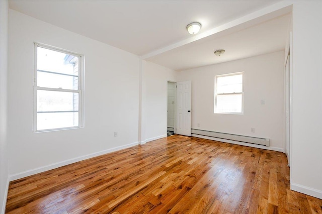 spare room featuring a wealth of natural light, light hardwood / wood-style floors, and baseboard heating