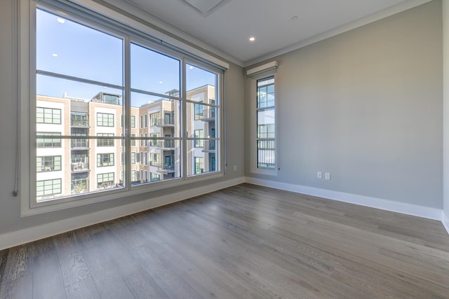 unfurnished room with crown molding and wood-type flooring