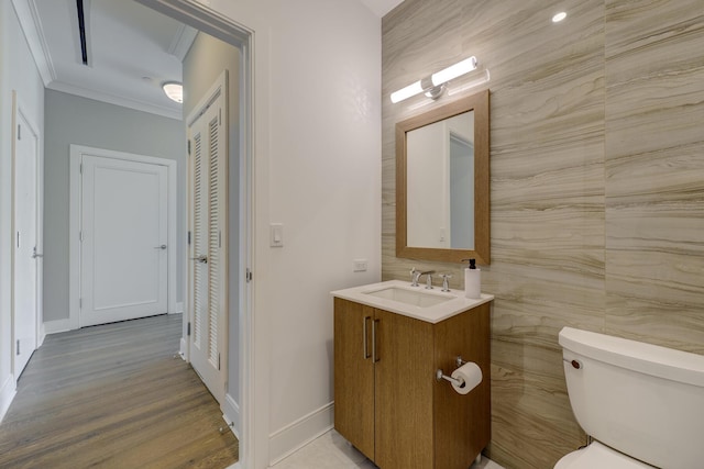 bathroom featuring ornamental molding, wood-type flooring, vanity, and toilet