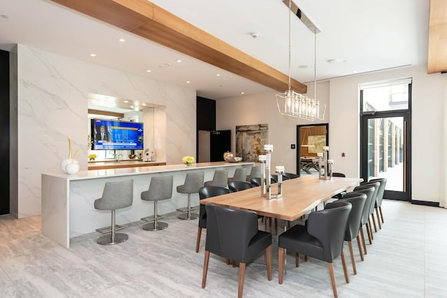 dining space featuring tile walls and beam ceiling