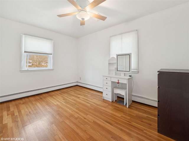 unfurnished office with ceiling fan, light wood-type flooring, and a baseboard radiator