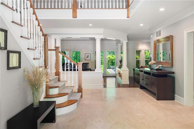 entrance foyer with decorative columns and ornamental molding