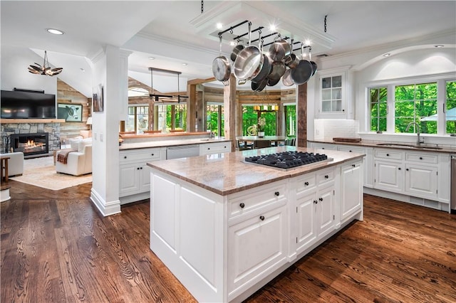 kitchen featuring dark hardwood / wood-style floors, white cabinetry, sink, a center island, and light stone countertops