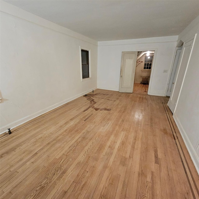 spare room featuring light wood-type flooring and radiator heating unit