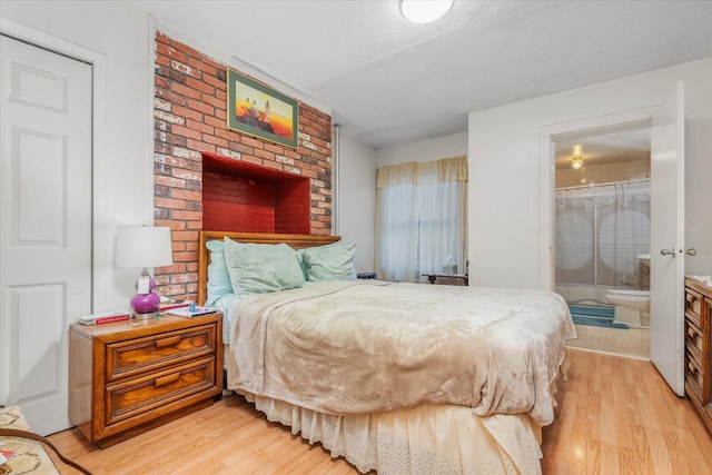 bedroom with light hardwood / wood-style flooring and ensuite bath