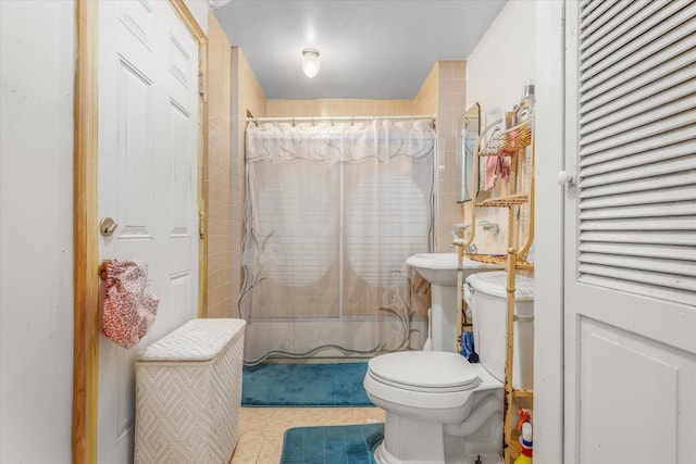 full bathroom with tile patterned floors, sink, shower / bath combo with shower curtain, and toilet