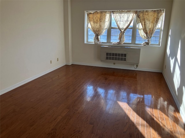 spare room featuring hardwood / wood-style flooring and heating unit