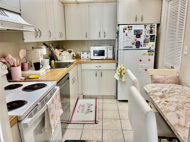 kitchen featuring white appliances, white cabinetry, and exhaust hood