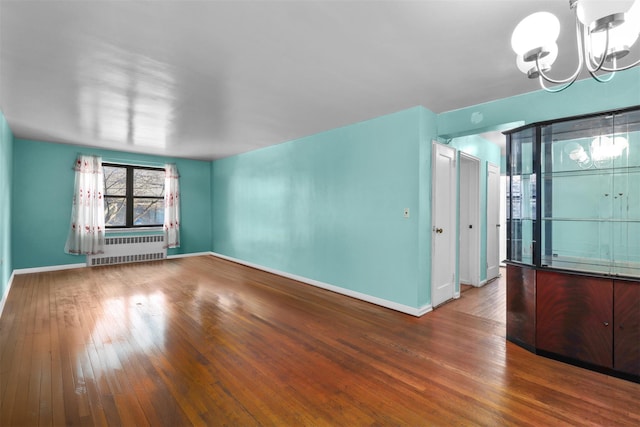 interior space with radiator, a chandelier, and hardwood / wood-style flooring