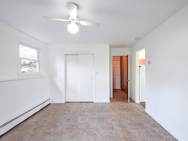 unfurnished bedroom with ceiling fan, a closet, and a baseboard radiator