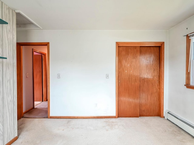 unfurnished bedroom with baseboard heating and light colored carpet