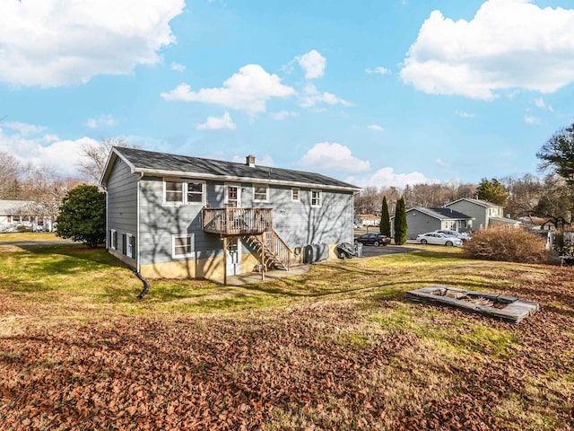 back of property featuring a wooden deck and a lawn