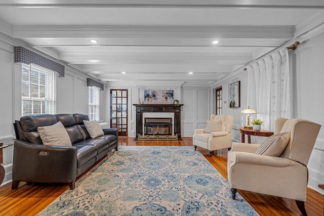 living room featuring ornamental molding, beam ceiling, and hardwood / wood-style floors