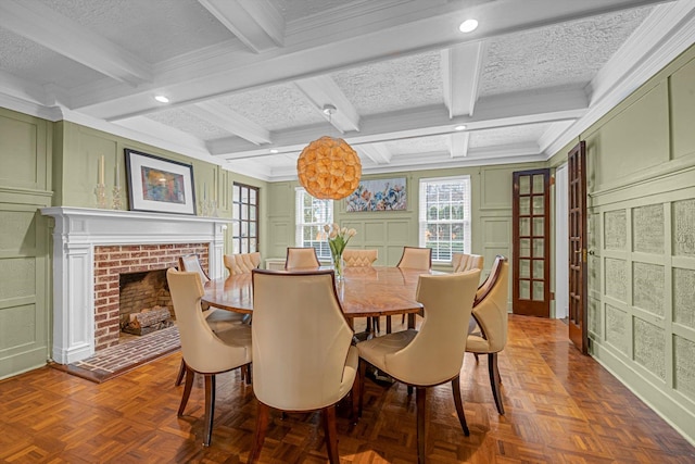 dining area featuring ornamental molding, parquet flooring, a fireplace, and beam ceiling