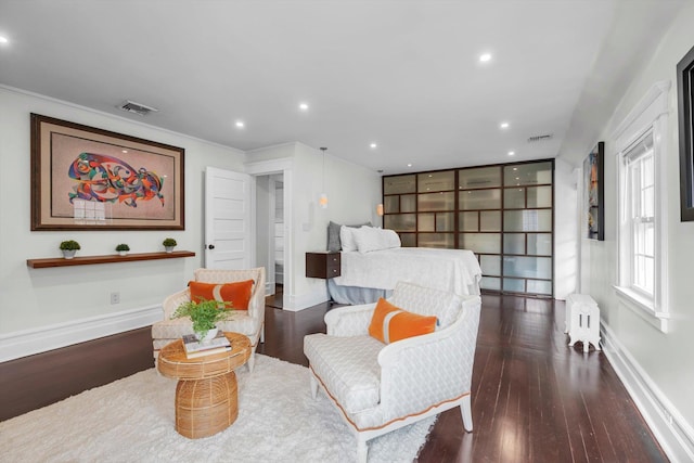 living area featuring dark hardwood / wood-style flooring, radiator, and crown molding