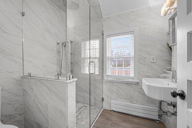 bathroom with a baseboard heating unit, sink, and walk in shower