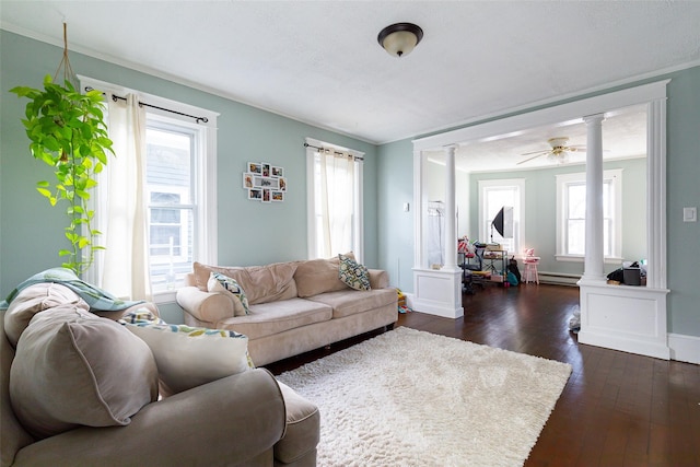 living room featuring ceiling fan, a baseboard heating unit, dark hardwood / wood-style flooring, and decorative columns