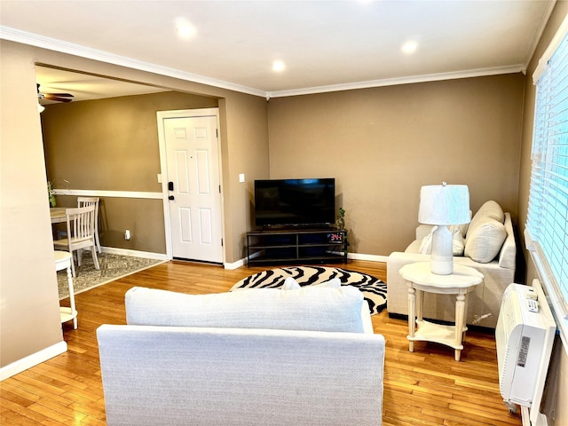 living room featuring heating unit, light hardwood / wood-style floors, ceiling fan, and ornamental molding