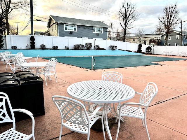 pool at dusk featuring a patio area