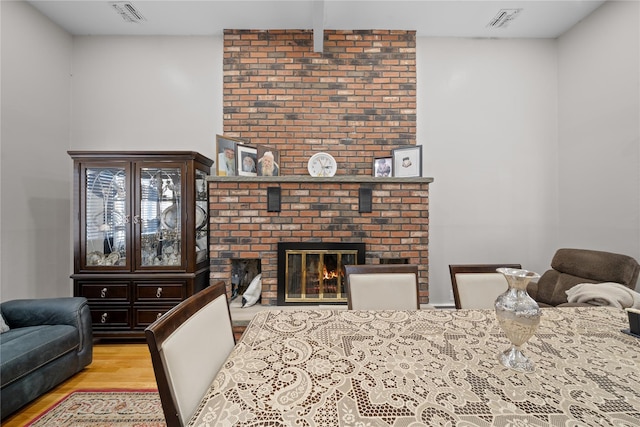 living room featuring light hardwood / wood-style flooring and a brick fireplace