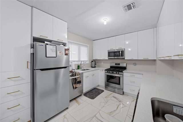 kitchen with sink, white cabinetry, and stainless steel appliances