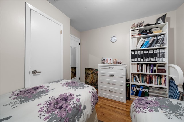 bedroom with light hardwood / wood-style floors and a closet