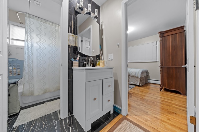 bathroom featuring shower / bath combination with curtain, vanity, baseboard heating, and wood-type flooring