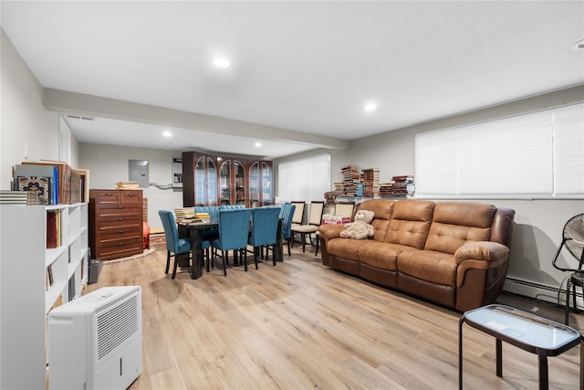 living room featuring light wood-type flooring and a baseboard heating unit