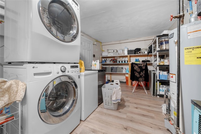 laundry area featuring stacked washer and dryer, light hardwood / wood-style floors, and water heater