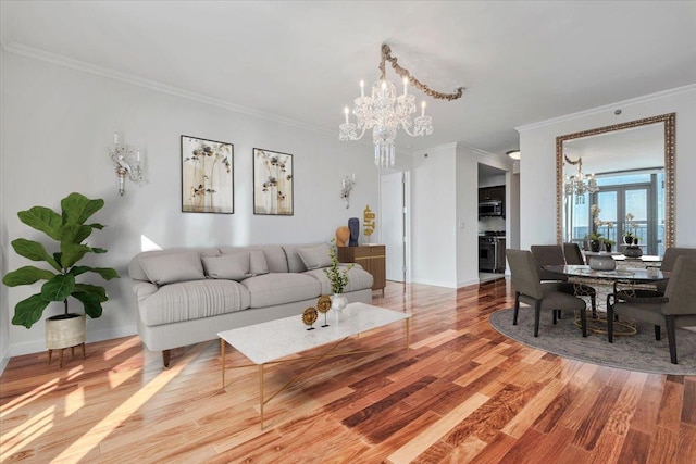 living room featuring ornamental molding, wood-type flooring, and a notable chandelier