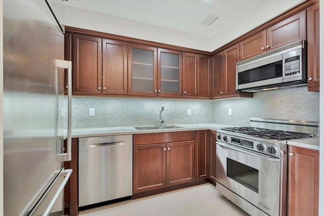 kitchen with visible vents, a sink, backsplash, appliances with stainless steel finishes, and light countertops