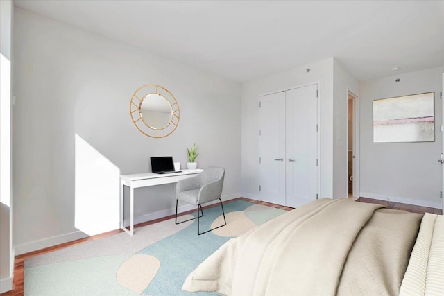 bedroom with light hardwood / wood-style floors and a closet