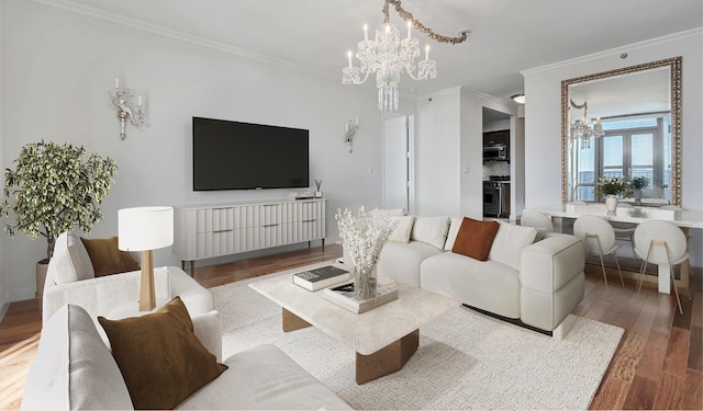 living room with a notable chandelier, wood finished floors, and crown molding