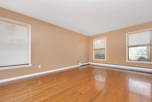 spare room featuring light wood-type flooring and a baseboard heating unit