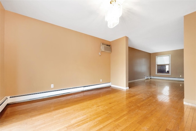 spare room with a wall mounted air conditioner, hardwood / wood-style floors, a baseboard radiator, and a notable chandelier