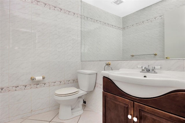 bathroom with tile patterned floors, vanity, toilet, and tile walls